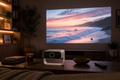 CineHaus Luma portable 1080p projector in a living room, about 8 feet from a 100-inch screen